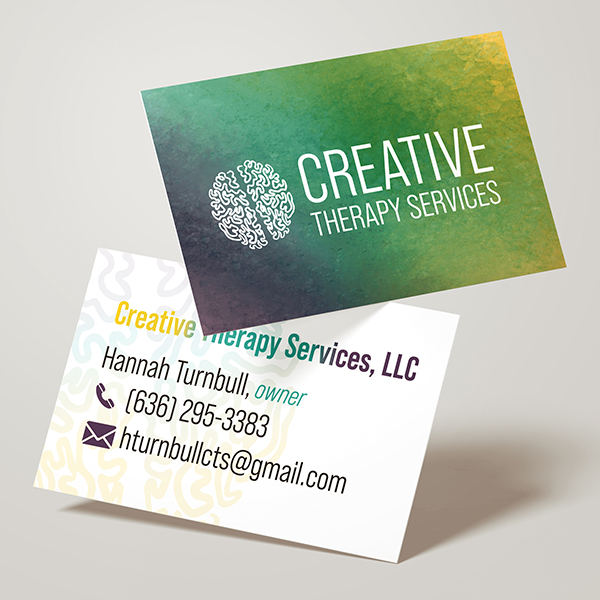 A stack of business cards sits with one card flipped and turned against a neutral background.