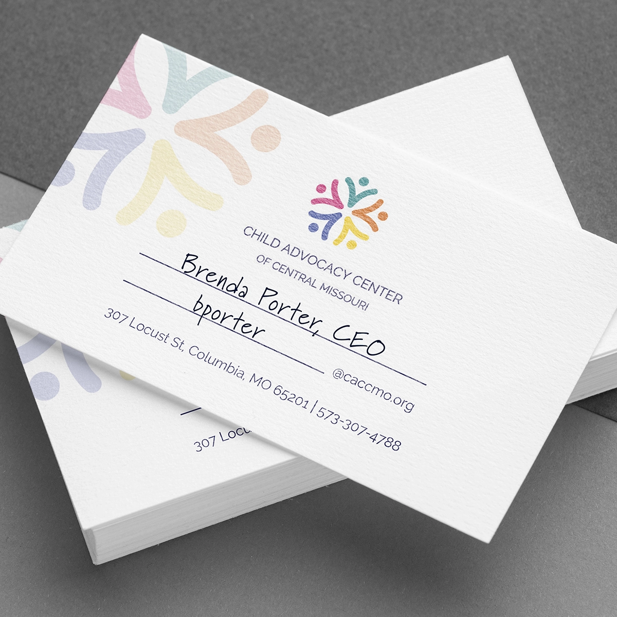 Stacked business card design for the Child Advocacy Center of Central Missouri featuring a warm, professional brand palette, colorful geometric logo elements, and clean contact information layout.